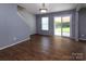 Inviting living room with wood-look flooring, stairway, and sliding door to the backyard at 7623 Monarch Birch Ln, Charlotte, NC 28215