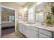 Bright bathroom features double sinks, white cabinets, neutral walls, and a view into the adjacent bedroom at 8232 Bretton Woods Dr, Charlotte, NC 28227