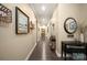 Long hallway with wood-look floors, neutral walls, and various decorative elements at 8232 Bretton Woods Dr, Charlotte, NC 28227