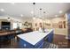 Open kitchen with a large center island, dining area, and blue cabinetry, blending style with functionality at 8232 Bretton Woods Dr, Charlotte, NC 28227