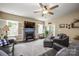Cozy living room featuring a fireplace, ceiling fan, neutral color palette, and lots of natural light at 8232 Bretton Woods Dr, Charlotte, NC 28227