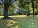 Large, grassy backyard featuring mature trees and two storage sheds at 8616 Fallsdale Dr, Charlotte, NC 28214