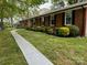 Well-maintained single-story brick home with manicured landscaping and a paved walkway at 8616 Fallsdale Dr, Charlotte, NC 28214