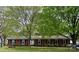 Charming brick home featuring a well-manicured lawn and mature trees providing ample shade at 8616 Fallsdale Dr, Charlotte, NC 28214