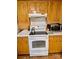 Close-up of the kitchen featuring white oven, cooktop, tile backsplash, and cabinets at 8616 Fallsdale Dr, Charlotte, NC 28214