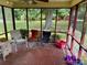 Relaxing screened porch with cozy seating, offering tranquil views of the expansive backyard at 8616 Fallsdale Dr, Charlotte, NC 28214
