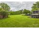 Wide shot of a large backyard with mature trees, a hot tub, a screened porch, and outbuildings at 1005 Fieldstone Rd, Mooresville, NC 28115