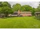 Expansive grassy backyard featuring a brick home, screened-in porch, and a soothing hot tub at 1005 Fieldstone Rd, Mooresville, NC 28115