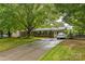 Brick home with an expansive driveway, green shutters, and charming decorative window boxes at 1005 Fieldstone Rd, Mooresville, NC 28115