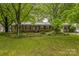 Charming brick home with green shutters, a well-manicured lawn, and mature trees at 1005 Fieldstone Rd, Mooresville, NC 28115