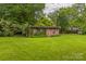 Charming outbuilding covered in ivy, nestled within a spacious and lush backyard at 1005 Fieldstone Rd, Mooresville, NC 28115