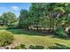 Expansive backyard featuring healthy green grass and mature trees at 104 Fairwind Ct, Fort Mill, SC 29708