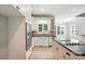 Open kitchen featuring stainless appliances, white cabinetry, tile flooring, and a breakfast bar at 104 Fairwind Ct, Fort Mill, SC 29708