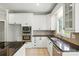 Bright kitchen features white cabinetry, stainless steel appliances, and mosaic tile backsplash at 104 Fairwind Ct, Fort Mill, SC 29708