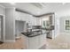 Bright kitchen features white cabinetry, stainless steel appliances, and a large kitchen island at 104 Fairwind Ct, Fort Mill, SC 29708
