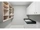Practical laundry room with open shelving, cabinets, and a utility sink at 104 Fairwind Ct, Fort Mill, SC 29708