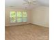 Spacious bedroom boasts natural light with many windows and neutral carpet at 10433 Blairbeth St, Charlotte, NC 28277
