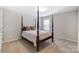 Bedroom featuring a four-poster bed, window, and neutral décor, offering a cozy and inviting space at 1133 Streamside Ln, York, SC 29745