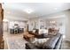 Open floor plan living room with an area rug, brown couches, and an adjacent kitchen at 1133 Streamside Ln, York, SC 29745