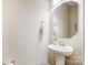 Simple and efficient powder room features pedestal sink, mirror and neutral walls at 1133 Streamside Ln, York, SC 29745