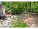 Landscaped backyard with a wooden deck, patio area, and mature trees at 122 Laurel Glen Dr, Mooresville, NC 28115