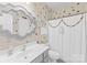 Charming bathroom with polka dot wall design, a decorative mirror, and a classic white sink and toilet at 122 Laurel Glen Dr, Mooresville, NC 28115