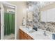 Bathroom with double vanity sinks, unique wallpaper, and a decorative mirror at 122 Laurel Glen Dr, Mooresville, NC 28115