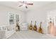 Bright and airy bedroom with natural light, ceiling fan, comfortable seating, and decorative guitars at 122 Laurel Glen Dr, Mooresville, NC 28115