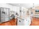 Bright open kitchen features white cabinets, island, stainless steel appliances, and hardwood floors at 122 Laurel Glen Dr, Mooresville, NC 28115