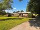 Charming brick ranch home with lush lawn and mature trees on a sunny day at 1243 Cox Mill Rd, Concord, NC 28027