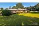 Quaint brick ranch home featuring mature landscaping and a well-manicured lawn at 1243 Cox Mill Rd, Concord, NC 28027