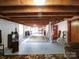 Open basement area with exposed ceiling beams, painted brick walls, and a large rug, offering versatile space at 1614 Linwood Rd, Gaston, NC 28052