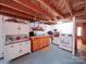 Basement kitchen features wood cabinets, a white oven, and ample storage, enhancing functionality in a unique setting at 1614 Linwood Rd, Gaston, NC 28052