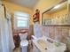 Bathroom featuring tiled walls, vintage sink, and charming fixtures at 1614 Linwood Rd, Gaston, NC 28052