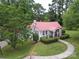 Charming home featuring a red metal roof, lush landscaping and a quaint front porch perfect for relaxation at 1614 Linwood Rd, Gaston, NC 28052