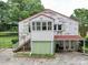 Unique white brick home featuring a red metal roof, wooden steps, and a covered patio at 1614 Linwood Rd, Gaston, NC 28052