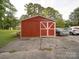 Outdoor shed with red siding and white trim, providing convenient storage and potential workshop space in the backyard at 1614 Linwood Rd, Gaston, NC 28052