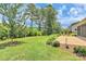 Large, lush backyard featuring manicured lawn, brick patio, and mature landscaping at 209 Van Gogh Trl, Mount Holly, NC 28120