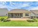 Rear exterior view of the home showcasing screened-in porch and brick patio at 209 Van Gogh Trl, Mount Holly, NC 28120