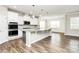 Modern kitchen features an island, stainless steel appliances, and ample counter space at 209 Van Gogh Trl, Mount Holly, NC 28120
