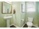 Charming powder room featuring a pedestal sink, modern toilet, and tasteful decor for a fresh, inviting space at 2246 Bluebell Way, Fort Mill, SC 29708