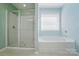 Bathroom showcasing a shower with glass door and a tub under a window at 2246 Bluebell Way, Fort Mill, SC 29708