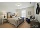 Cozy bedroom with a dark metal bed frame, bedside tables, neutral decor, and a comfortable chair at 2246 Bluebell Way, Fort Mill, SC 29708