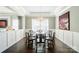 Elegant dining room featuring a round glass table, stylish chandelier, wainscoting and hardwood floors at 2246 Bluebell Way, Fort Mill, SC 29708