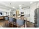 Open concept kitchen features stainless appliances, granite counters, white cabinets and bar seating at the island at 2246 Bluebell Way, Fort Mill, SC 29708