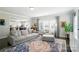 Bright living room boasts a large sofa, chair, ottoman, area rug and plenty of natural light from the large window at 2246 Bluebell Way, Fort Mill, SC 29708