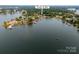 Aerial view shows a lakeside home with a boat dock and mature trees at 22501 John Gamble Rd, Cornelius, NC 28031