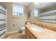 Well-lit bathroom featuring a granite countertop, ample storage, and a shower with classic striped shower curtain at 22501 John Gamble Rd, Cornelius, NC 28031