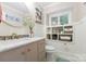 Stylish bathroom featuring a round mirror, a white marble countertop, and a unique shelf above the toilet at 22501 John Gamble Rd, Cornelius, NC 28031