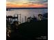 Picturesque waterfront view with docks, palm trees, and a colorful sunset reflected on the calm water at 22501 John Gamble Rd, Cornelius, NC 28031